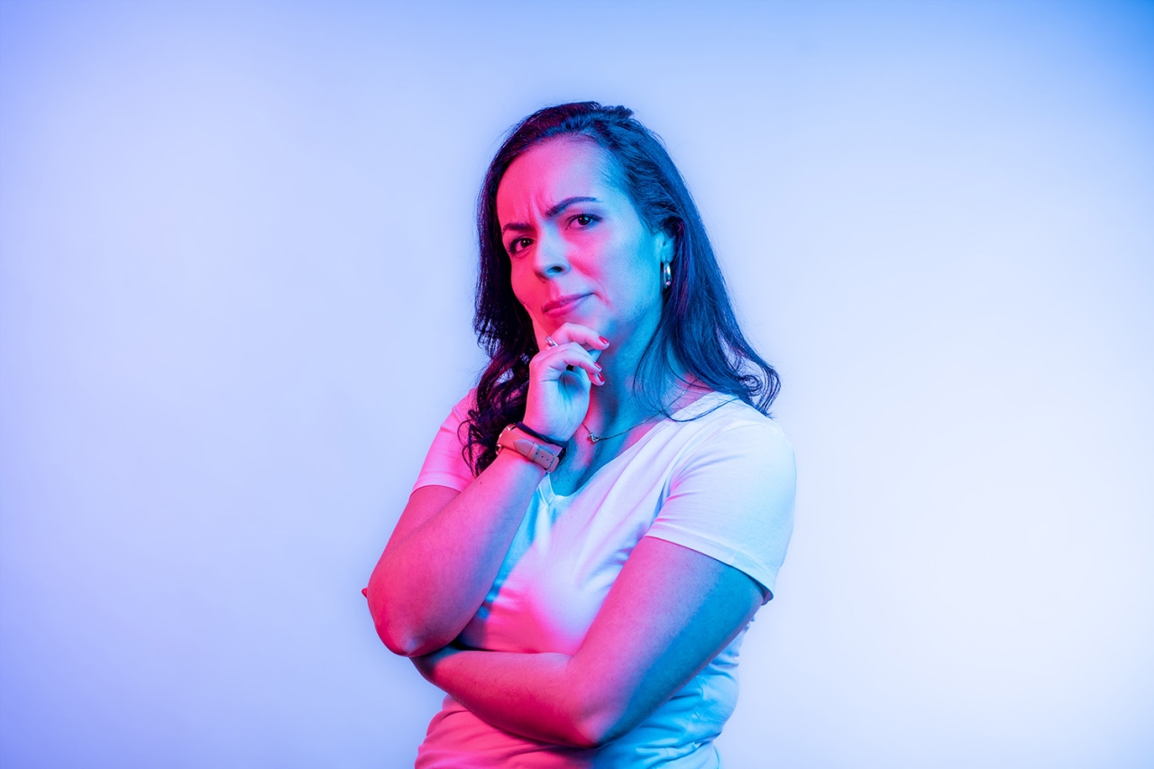 Mujer se lleva la mano a la barbilla, melancólica