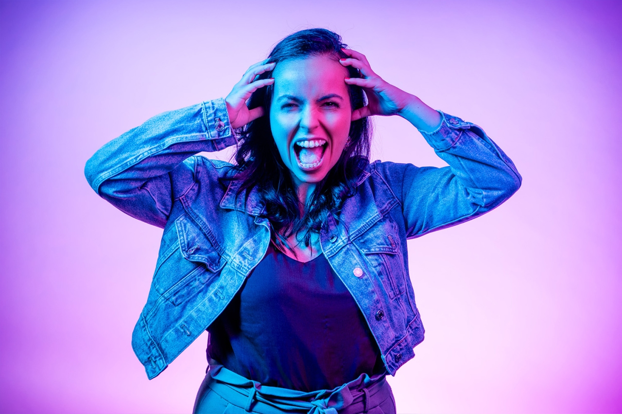 Woman holds her hands to her head 