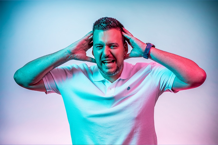 Mann hält Hände an Kopf und schreit