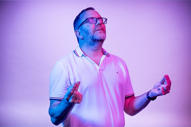 El hombre tiene los ojos cerrados y las manos frente a él 